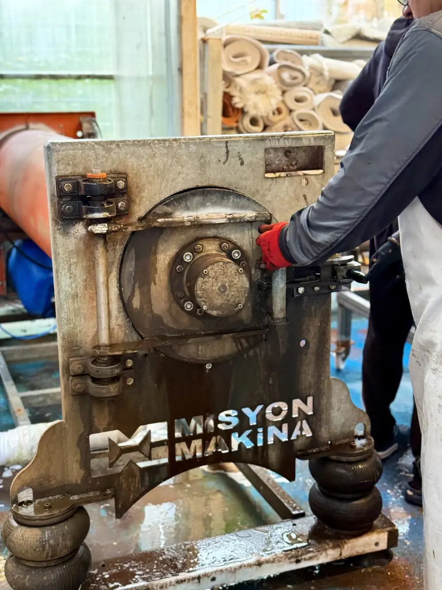 Zümrüt tesisinde görevli halı yıkama makinesini kullanırken
